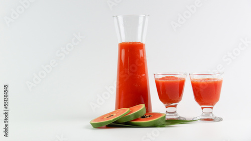 Papaya smoothie in glass jar and glasses on white background diet vegetarian healthy and freshness drink concept soft and selective focus