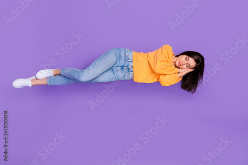 Full length photo of pretty cute lady laying hand under face dressed orange fall cozy trendy clothes isolated on purple color background