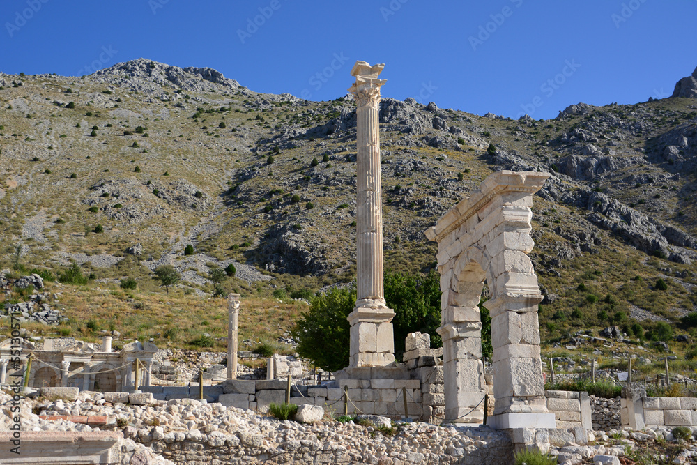 ancient arch and ruins of historic town Sagalassos with mountains on background