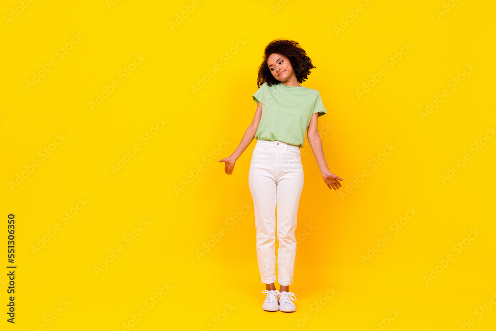Full size photo of young attractive gorgeous nice woman wear green t-shirt look down palms no idea isolated on bright yellow color background Full size photo of young attractive gorgeous nice woman wear green t-shirt look down palms no idea isolated on bright yellow color background