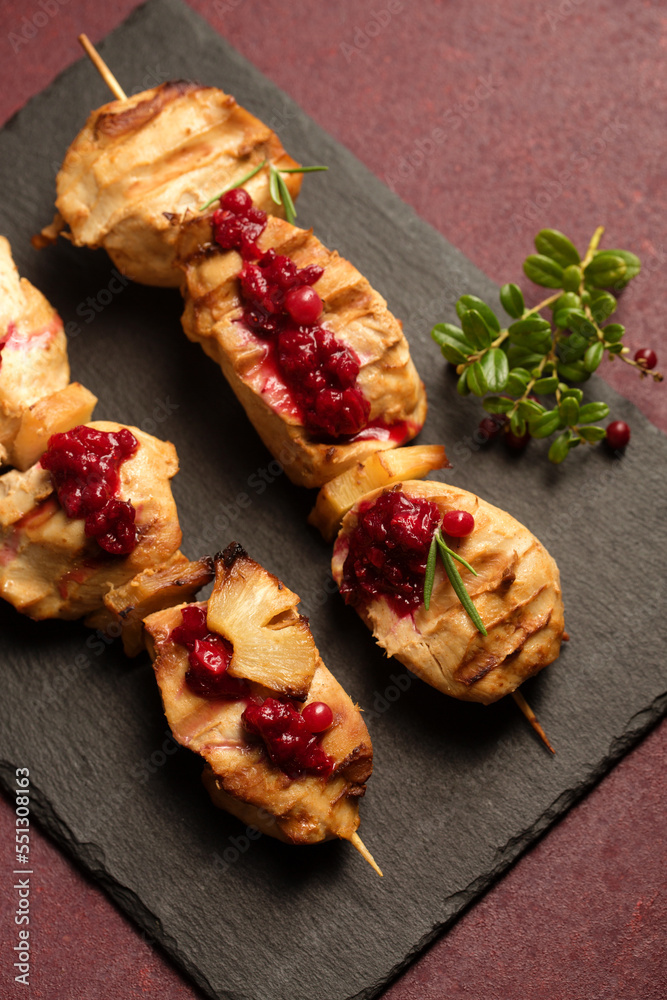 Chicken kebab with spices and lingonberry sauce on a stone tablet