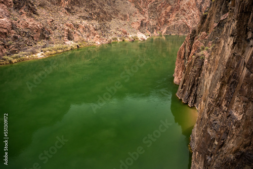 Calm Waters Of The Colorado River Turns The Corner Around A Tall Cliff