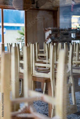 Wooden chairs on the tables of an empty and closed restaurant © MiguelAngel