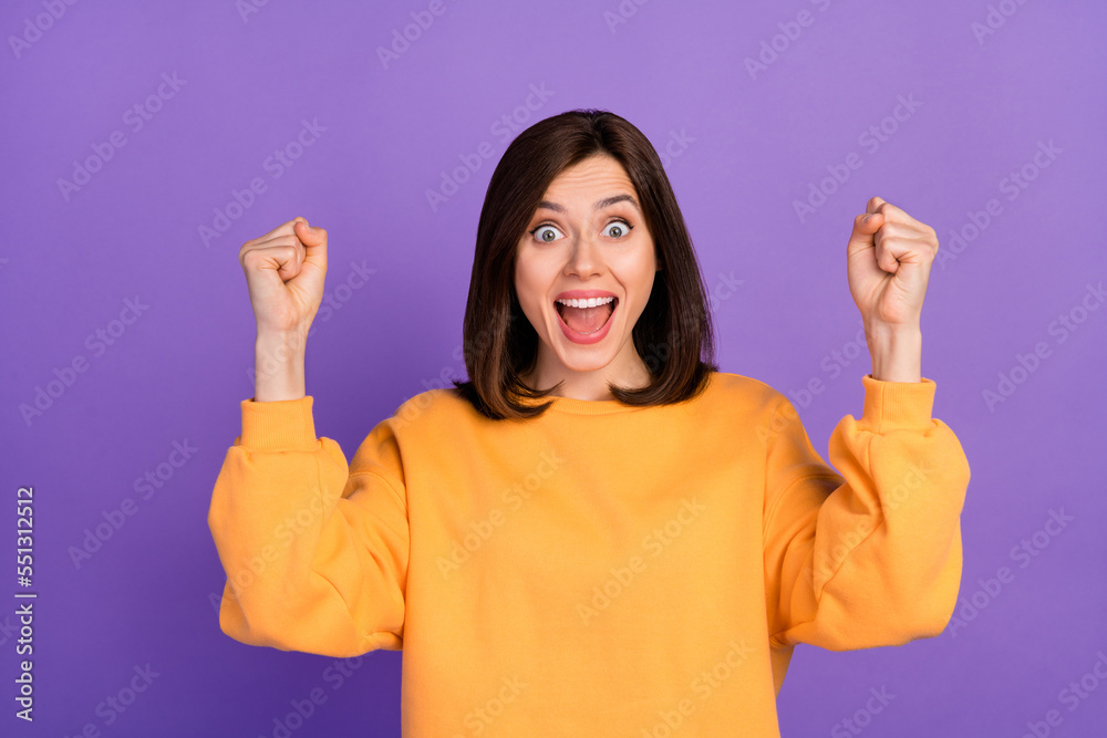 Full body size photo of young adorable pretty girl wear yellow sweater fists up excited positive hooray yeah winner isolated on purple color background