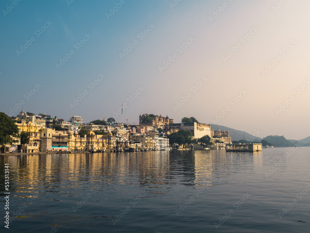OUdaipur, Rajasthan, India - december 4th 2022: mid range view of pichola lake and city palace from hanuman ghat