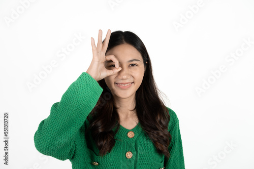 Happy young Asian woman feeling happiness and gesture showing OK hand sign on isolated white background.