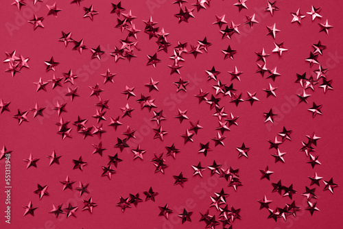 Viva Magenta stars glitter confetti as background. Party holiday backdrop. View from above  flat lay style. Trending color of 2023 - Viva Magenta.