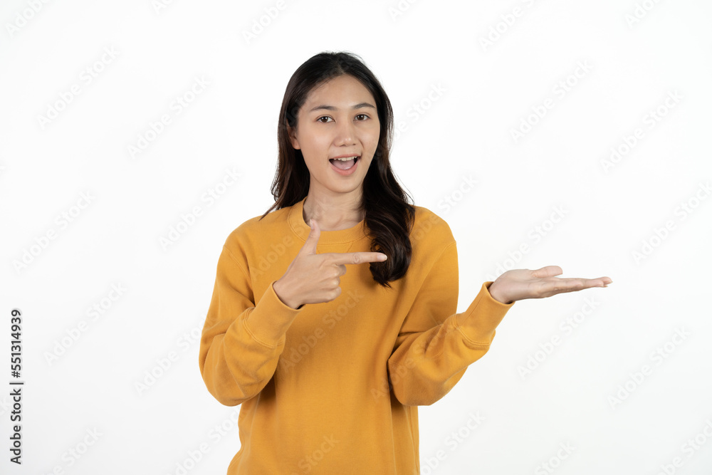Young beautiful Asian businesswoman smiling and pointing to empty copy space isolated on white background. Young beautiful Asian businesswoman smiling and pointing to empty copy space isolated on white background.