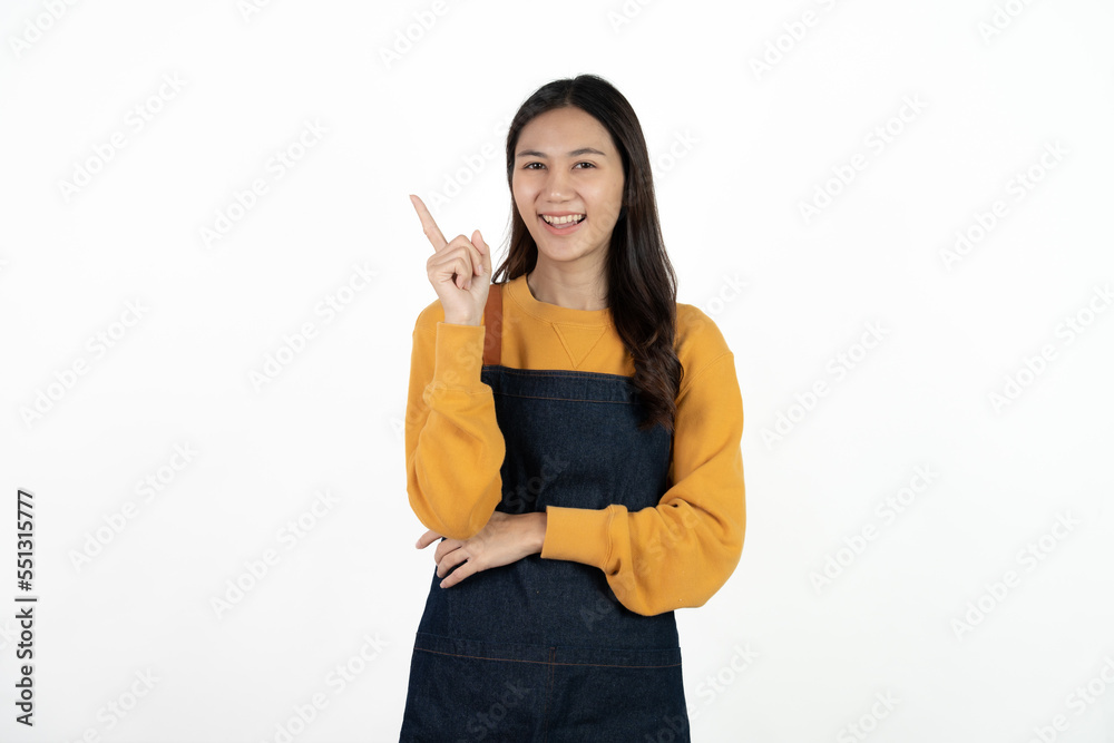 Young beautiful woman with apron standing on isolated white background pointing finger to blank space. Young beautiful woman with apron standing on isolated white background pointing finger to blank space.