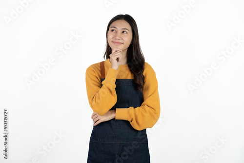 Young beautiful woman with apron standing on isolated white background pointing finger to blank space.