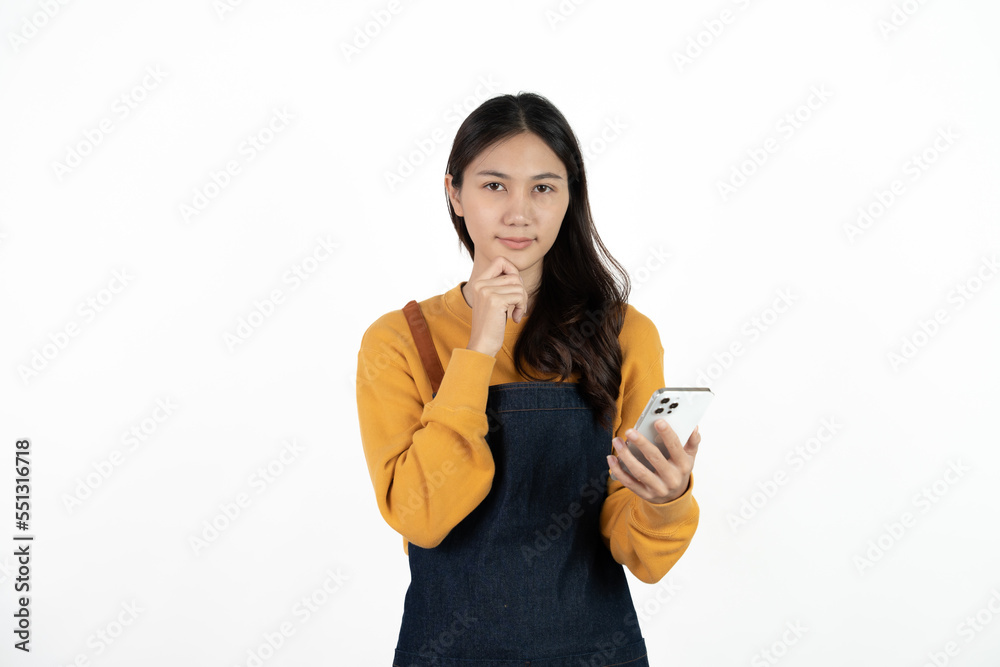 Happy young asian woman business owner wear apron and holding smartphone for checking order from customer isolated on white background for SME franchise investment concept. Happy young asian woman business owner wear apron and holding smartphone for checking order from customer isolated on white background for SME franchise investment concept.