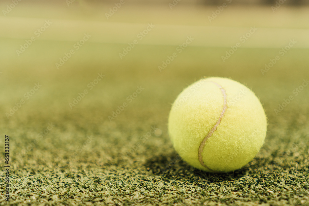 Yellow paddle ball on green artificial grass track after a championship