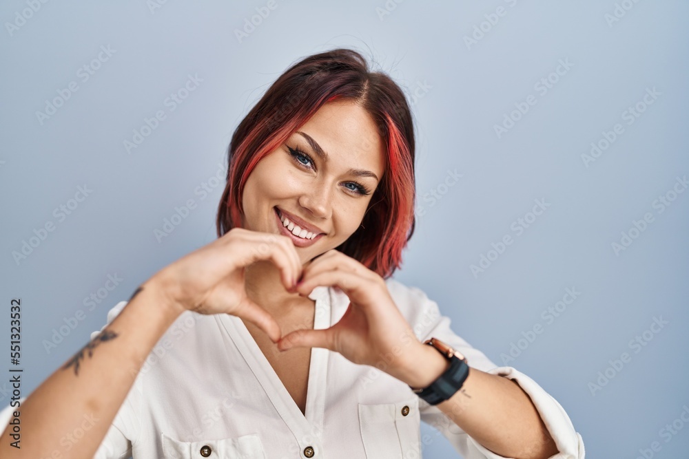 Young caucasian woman wearing casual white shirt over isolated background smiling in love doing heart symbol shape with hands. romantic concept. Young caucasian woman wearing casual white shirt over isolated background smiling in love doing heart symbol shape with hands. romantic concept.
