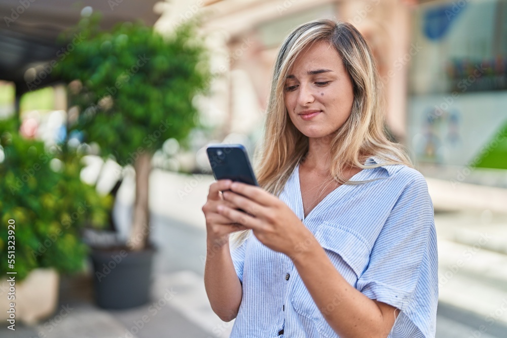 Young blonde woman smiling confident using smartphone at street Young blonde woman smiling confident using smartphone at street