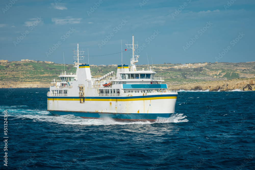 Ferry traveling on the gozo malta channel line between the city of Mgarr and Cirkewwa on rough waters on a sunny day.