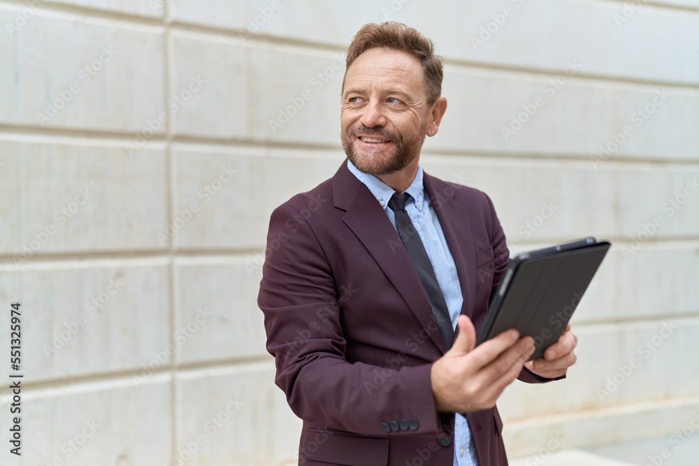 Middle age man business worker smiling confident using touchpad at street Middle age man business worker smiling confident using touchpad at street