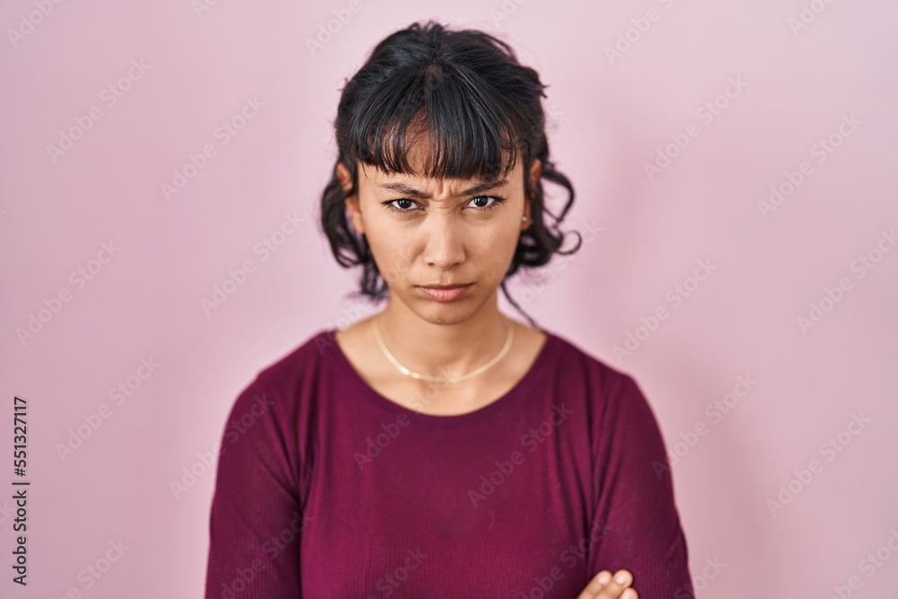 Young beautiful woman standing over pink background skeptic and nervous, frowning upset because of problem. negative person.