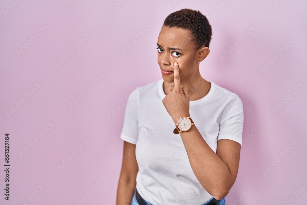 Beautiful african american woman standing over pink background pointing to the eye watching you gesture, suspicious expression Beautiful african american woman standing over pink background pointing to the eye watching you gesture, suspicious expression