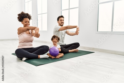 Couple and daughter smiling confident stretching at sport center