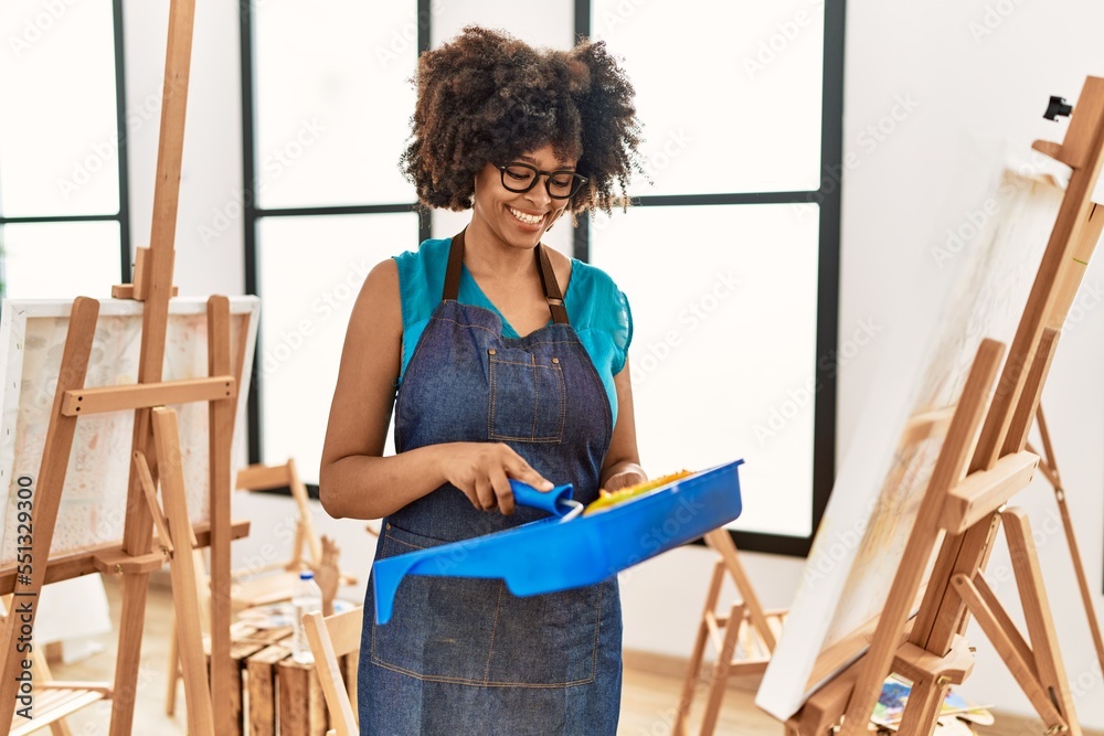 Young african american woman smiling confident drawing using roller at art studio