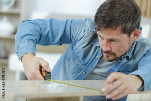 carpenter measure wooden board in his workshop