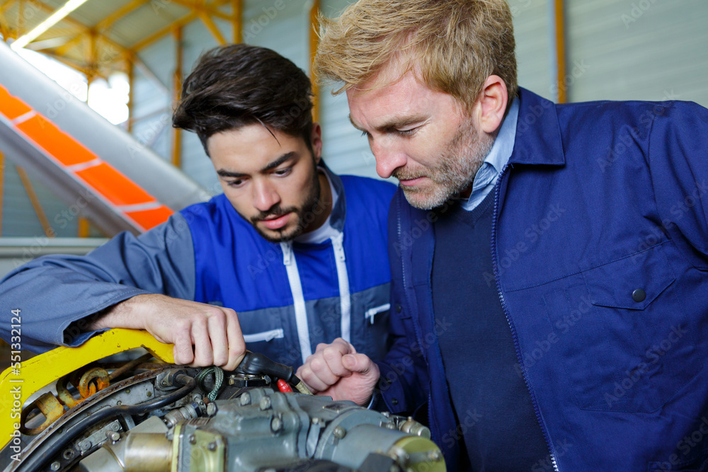 men working on engine of the airplane men working on engine of the airplane