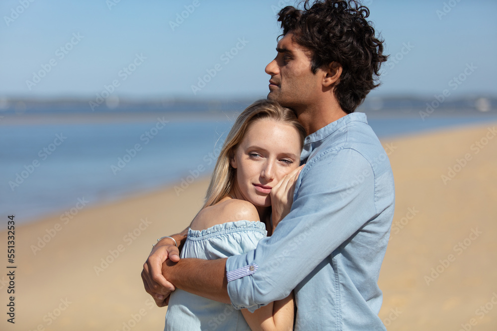 attractive couple cuddling at the beach