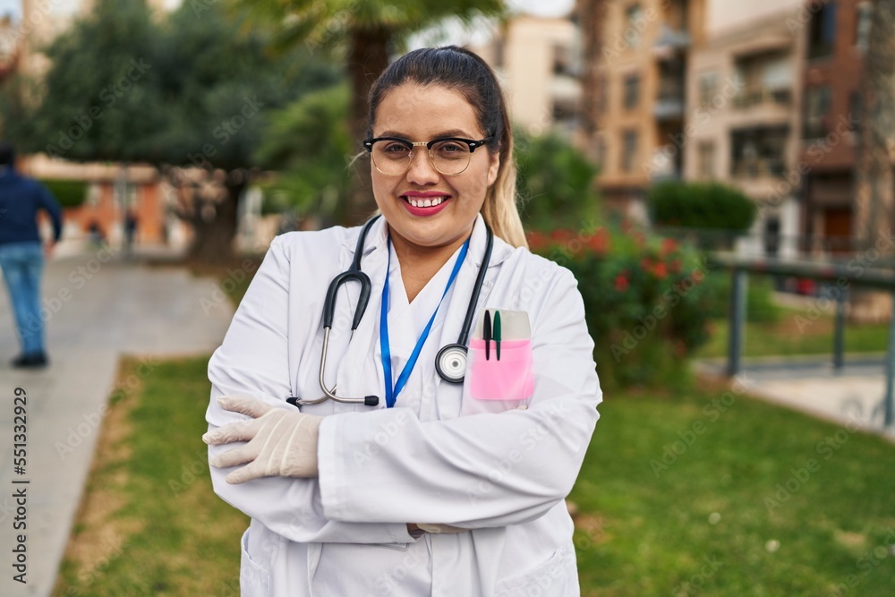 Young beautiful plus size woman doctor smiling confident standing with arms crossed gesture at park Young beautiful plus size woman doctor smiling confident standing with arms crossed gesture at park