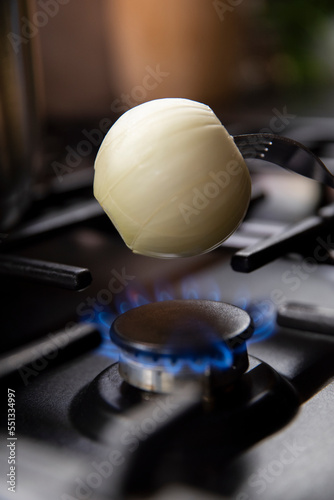 Cebula opalana nad palnikiem na kuchence gazowej