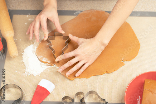 cooking gingerbread cookies, cutting out shapes from dough 