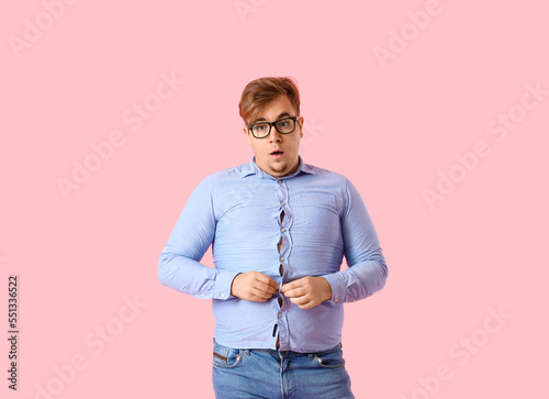 Slika na platnu Young overweight man in tight shirt on pink background