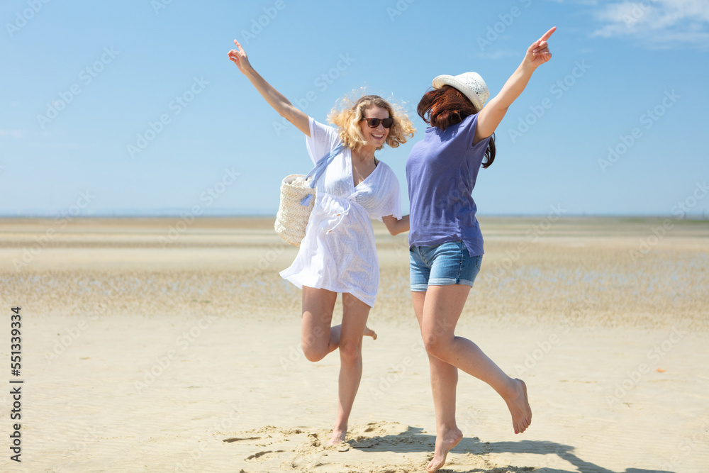 friends having fun and dancing on the beach