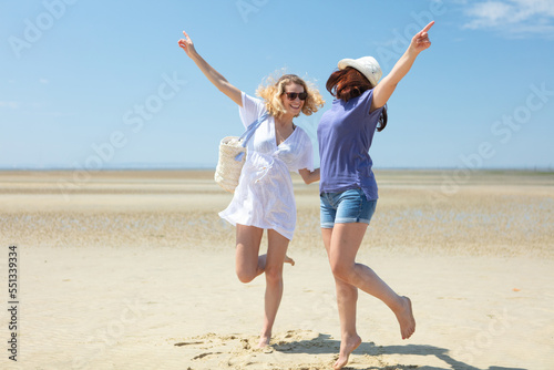 friends having fun and dancing on the beach