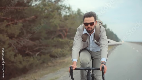 Man in business suit hurrying to work on bicycle 