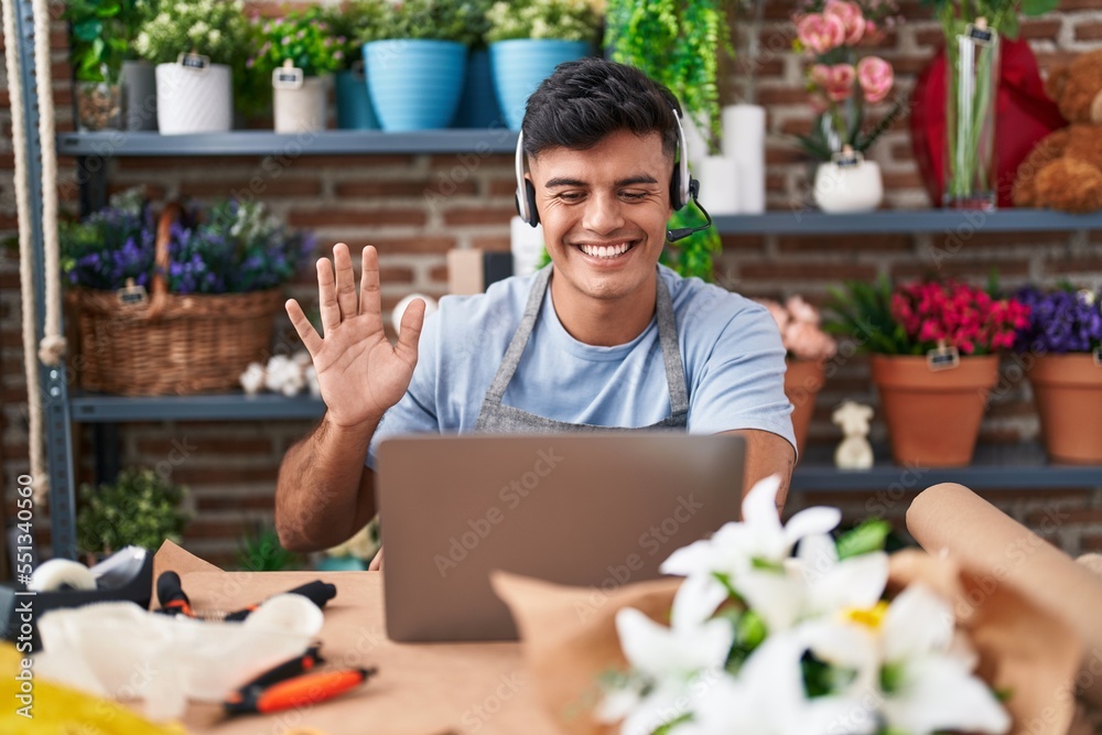 Hispanic young man working at florist shop doing video call looking positive and happy standing and smiling with a confident smile showing teeth Hispanic young man working at florist shop doing video call looking positive and happy standing and smiling with a confident smile showing teeth