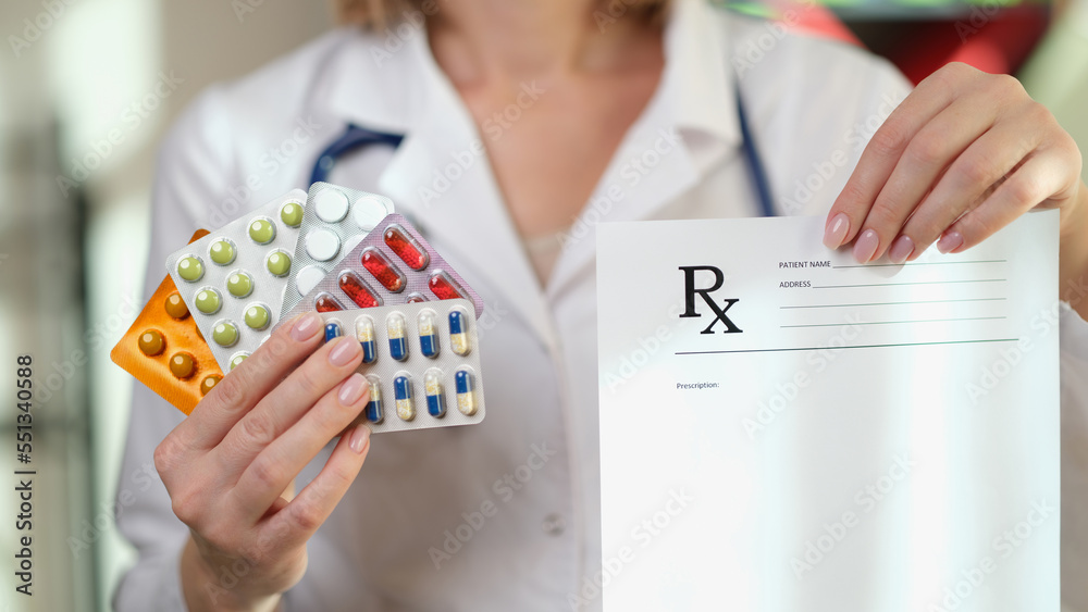 Doctor shows many packages of different pills and blank prescriptions. Doctor shows many packages of different pills and blank prescriptions.