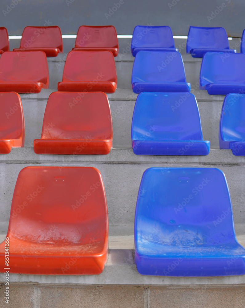 Naklejka premium Symmetry tier of empty blue and red seats on a soccer field. Seats in the colors of Barça.