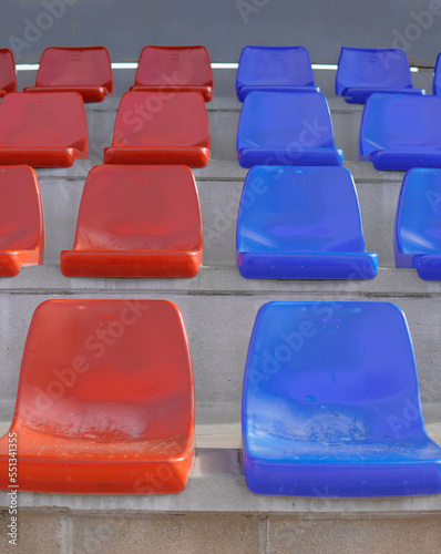 Symmetry tier of empty blue and red seats on a soccer field. Seats in the colors of Bar  a.