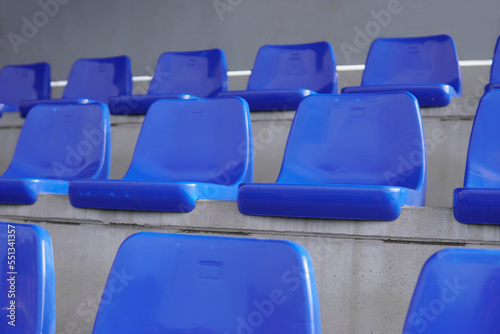 closeup of empty blue seats tier on soccer field.