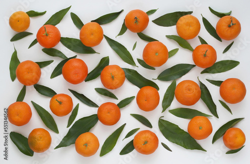 Fruit pattern from fresh mandarin and leaves on white background. Citrus background from fresh whole tangerines. Top view. Flat lay.