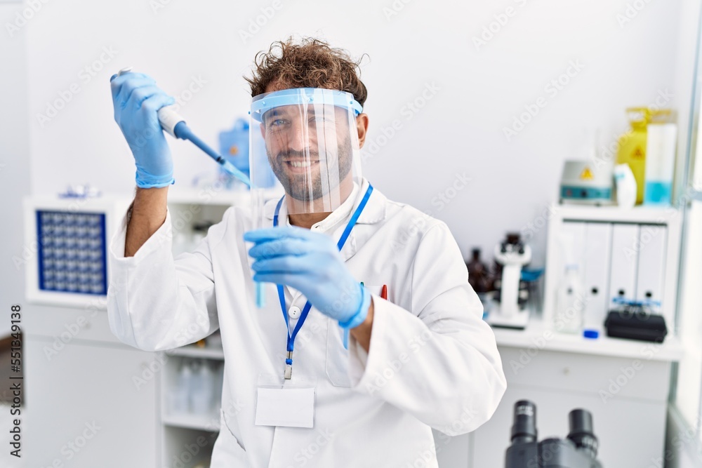 Young hispanic man wearing scientist uniform working at laboratory Young hispanic man wearing scientist uniform working at laboratory