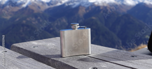 a hip flask on a table in the mountains photo