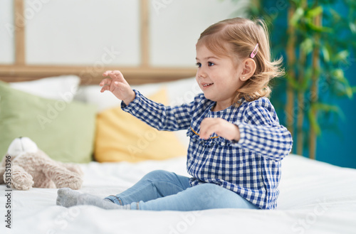 Adorable hispanic girl smiling confident standing on bed at bedroom