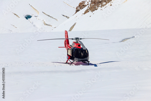 Red helicopter landed at Jungfrau mountain in Bernese Oberland, Switzerland