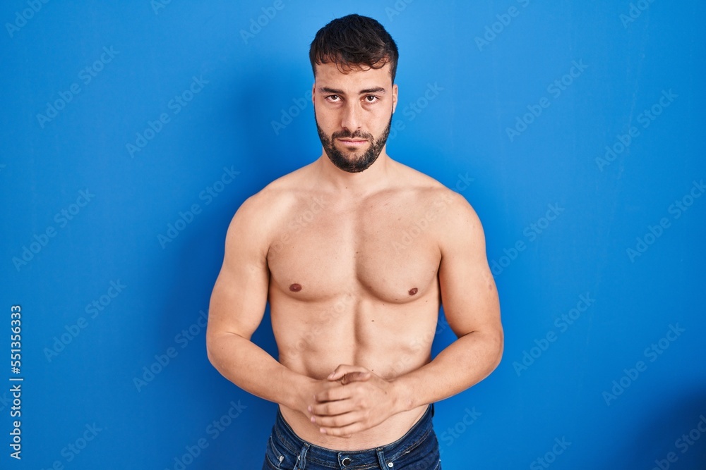 Handsome hispanic man standing shirtless depressed and worry for distress, crying angry and afraid. sad expression. Handsome hispanic man standing shirtless depressed and worry for distress, crying angry and afraid. sad expression.