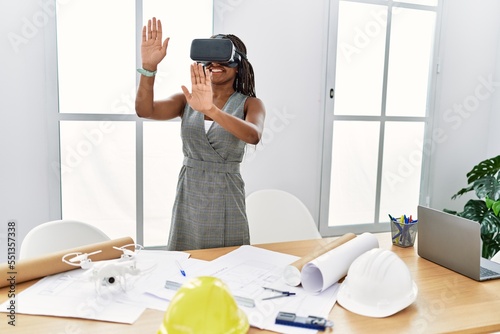 Young african american woman architect using virtual reality glasses at architecture studio photo