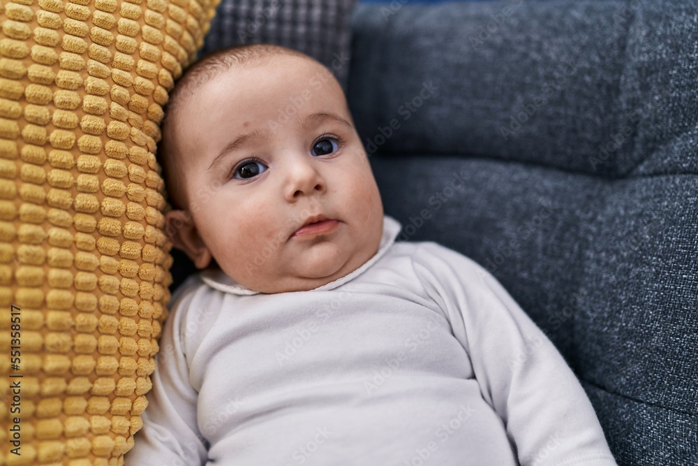 Adorable baby relaxed sitting on sofa at home Adorable baby relaxed sitting on sofa at home