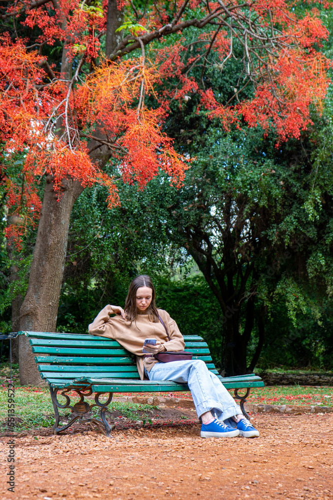 Fototapeta premium a young girl in the park sitting under a tree