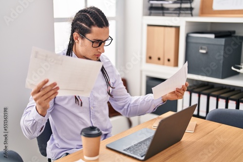 Young man business worker reading document working at office