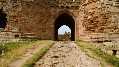 Establishing shot of Dunstanburgh Castle, a 14th-century fortification on the coast of Northumberland in northern England, UK photo